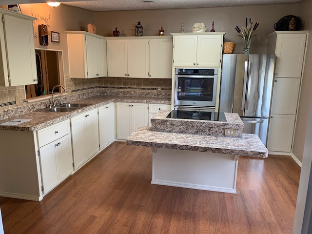Large l-shaped eat-in kitchen photo with shaker cabinets, beige cabinets, laminate countertops, an island and brown countertops
