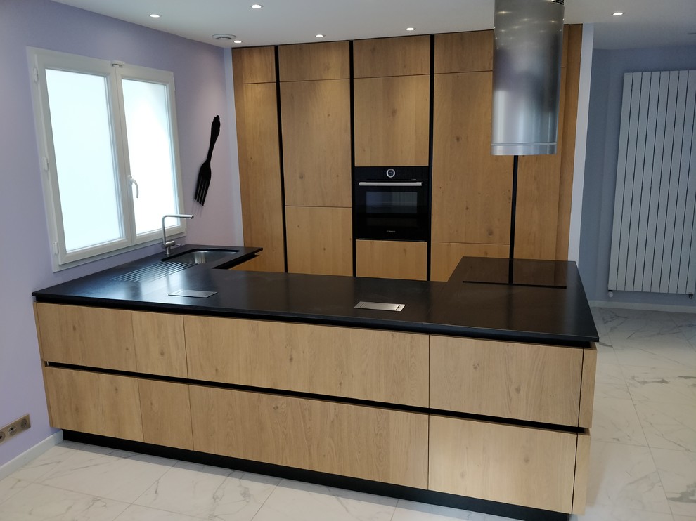 Inspiration pour cuisine américaine en U avec un plan de travail en granite et plan de travail noir.