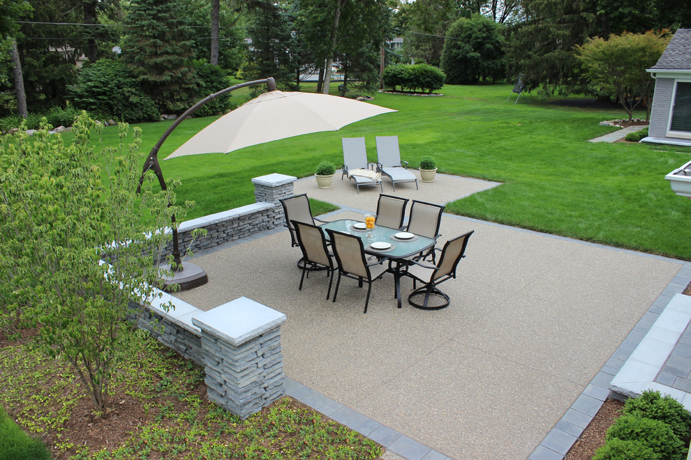 This is an example of a mid-sized transitional backyard patio in Detroit with decomposed granite and no cover.