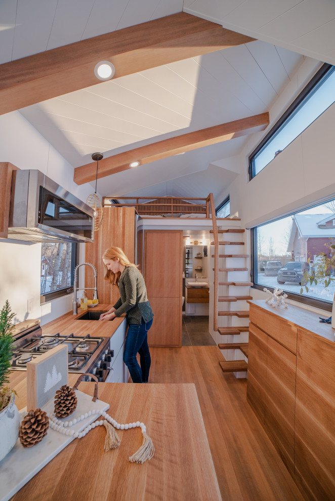 На фото: кухня в скандинавском стиле с деревянной столешницей и светлым паркетным полом