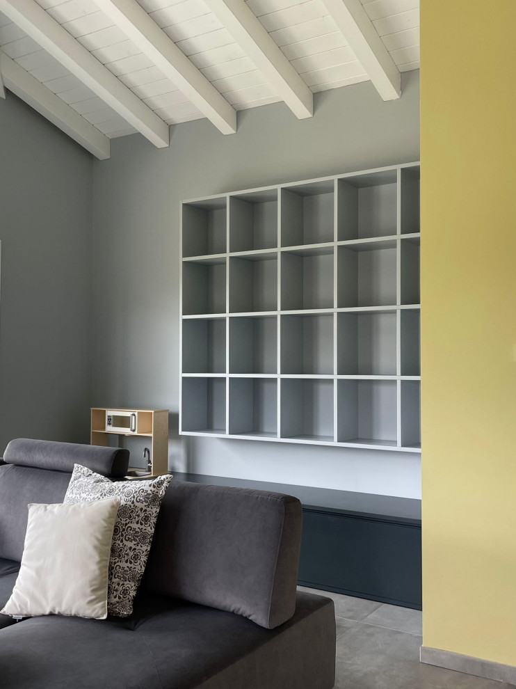 Immagine di un piccolo soggiorno moderno con libreria, pareti blu e pavimento grigio