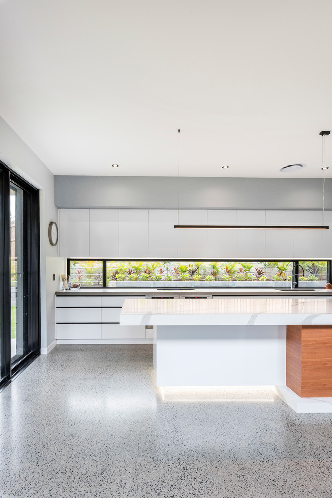 Inspiration for a contemporary galley kitchen in Brisbane with an undermount sink, flat-panel cabinets, grey cabinets, concrete benchtops, window splashback, concrete floors, with island, grey floor and grey benchtop.
