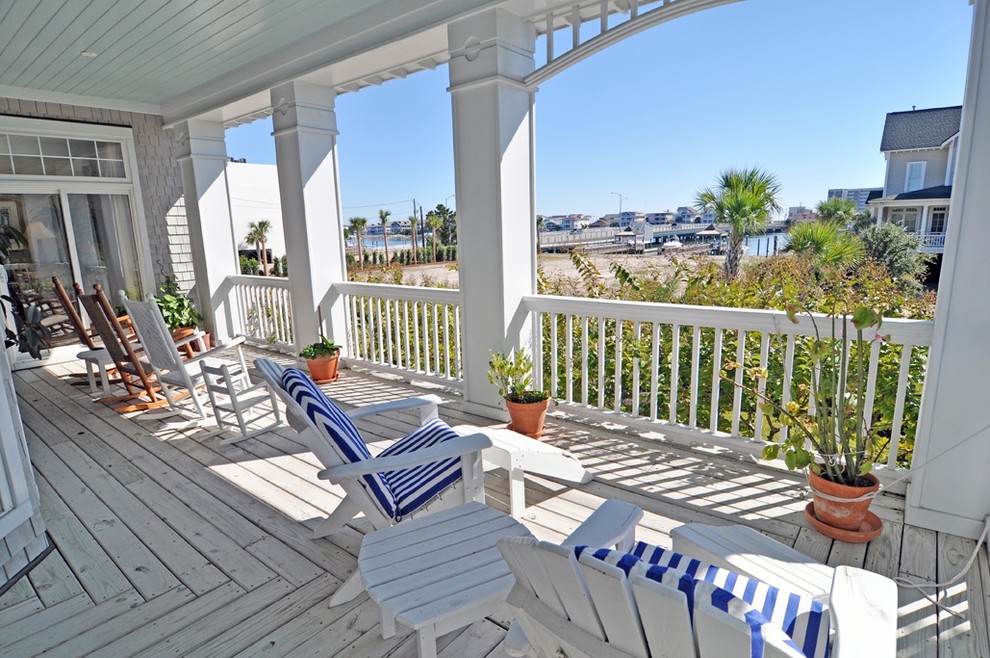 This is an example of a mid-sized beach style front yard verandah in Wilmington with a roof extension and decking.