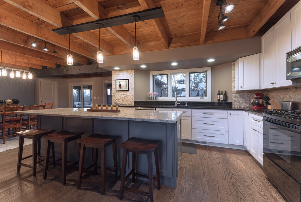 This is an example of a country eat-in kitchen in Chicago with granite benchtops, multi-coloured splashback, medium hardwood floors and with island.