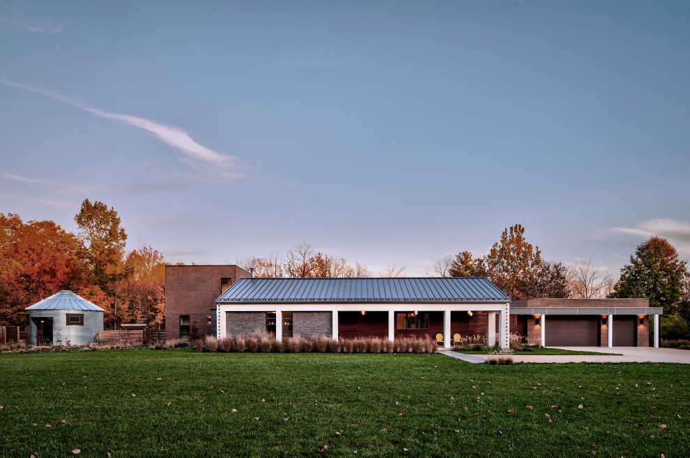 Modelo de fachada de casa marrón y gris moderna de tamaño medio de una planta con revestimiento de estuco, tejado a dos aguas, tejado de metal y tablilla