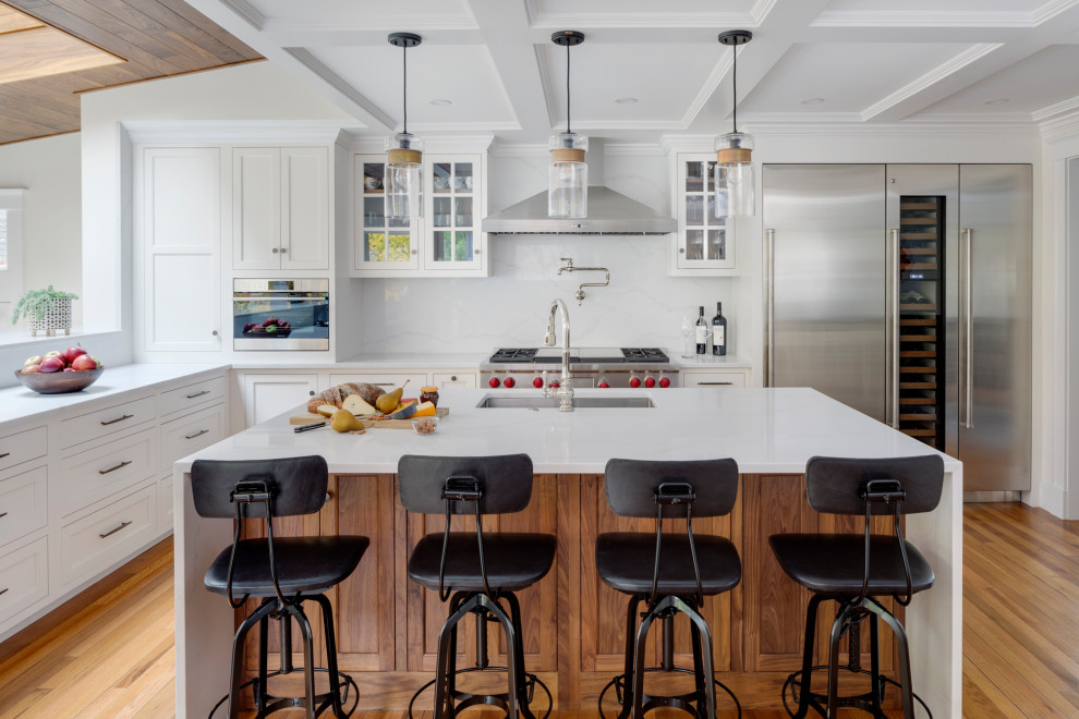 Large transitional l-shaped kitchen in Boston with a single-bowl sink, recessed-panel cabinets, white cabinets, marble benchtops, white splashback, marble splashback, stainless steel appliances, medium hardwood floors, with island and yellow benchtop.