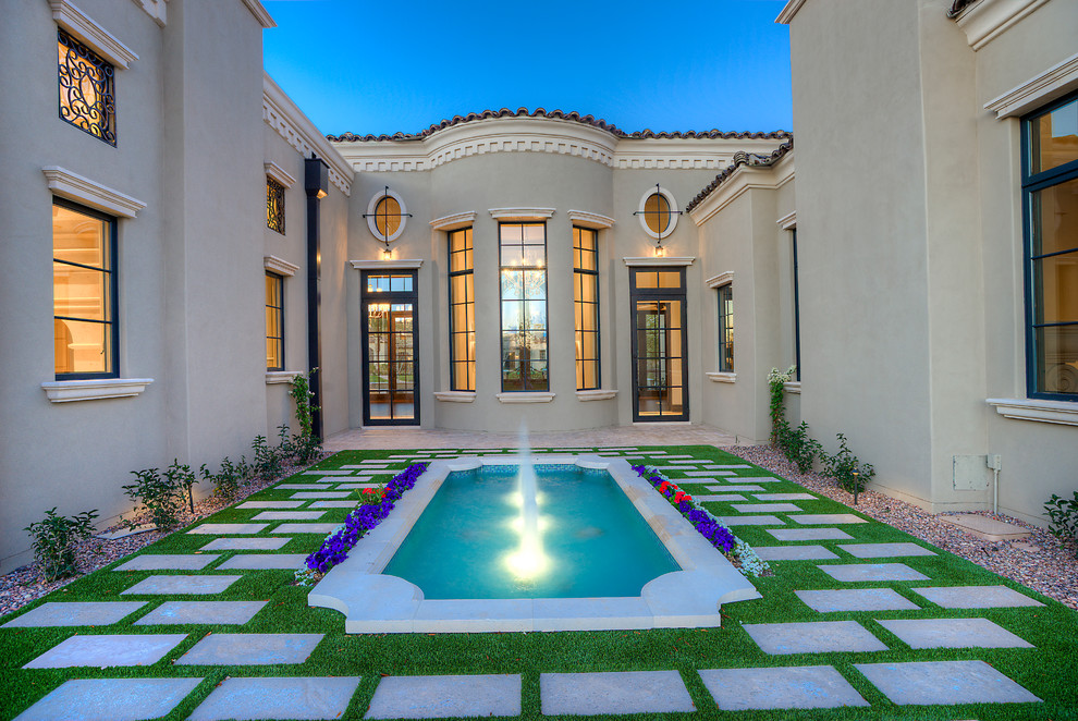 Photo of a large mediterranean courtyard formal garden in Phoenix with a water feature.
