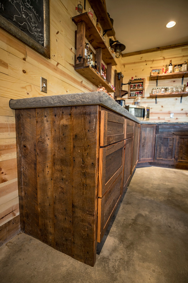 This is an example of a small country u-shaped eat-in kitchen in Wichita with a farmhouse sink, shaker cabinets, distressed cabinets, concrete benchtops, brown splashback, timber splashback, stainless steel appliances, concrete floors, with island and grey floor.