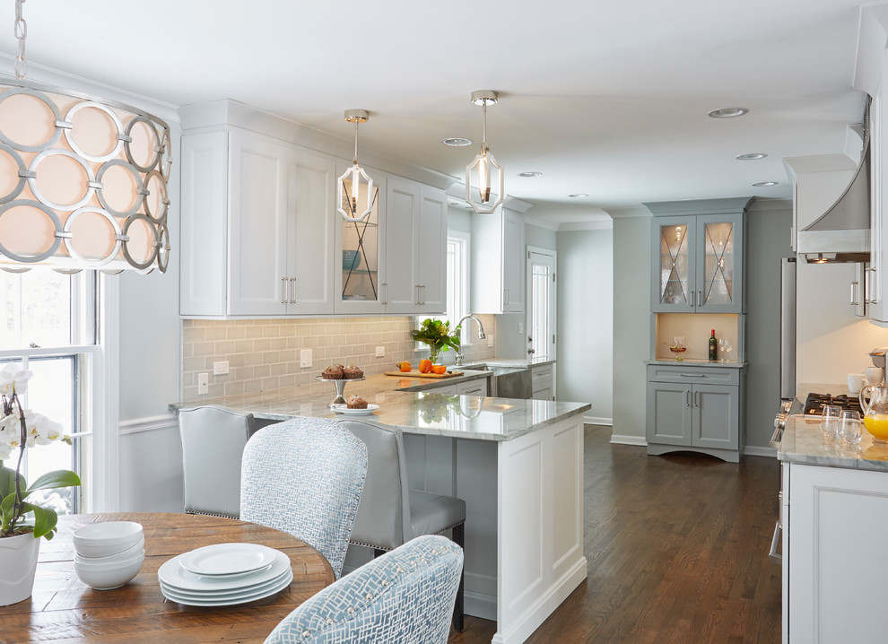 Example of a transitional medium tone wood floor eat-in kitchen design in Chicago with a single-bowl sink, flat-panel cabinets, white cabinets, quartzite countertops, gray backsplash, subway tile backsplash, stainless steel appliances and a peninsula