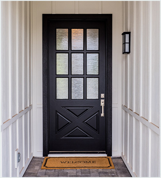 Foto di un ingresso o corridoio country con pareti bianche e una porta nera
