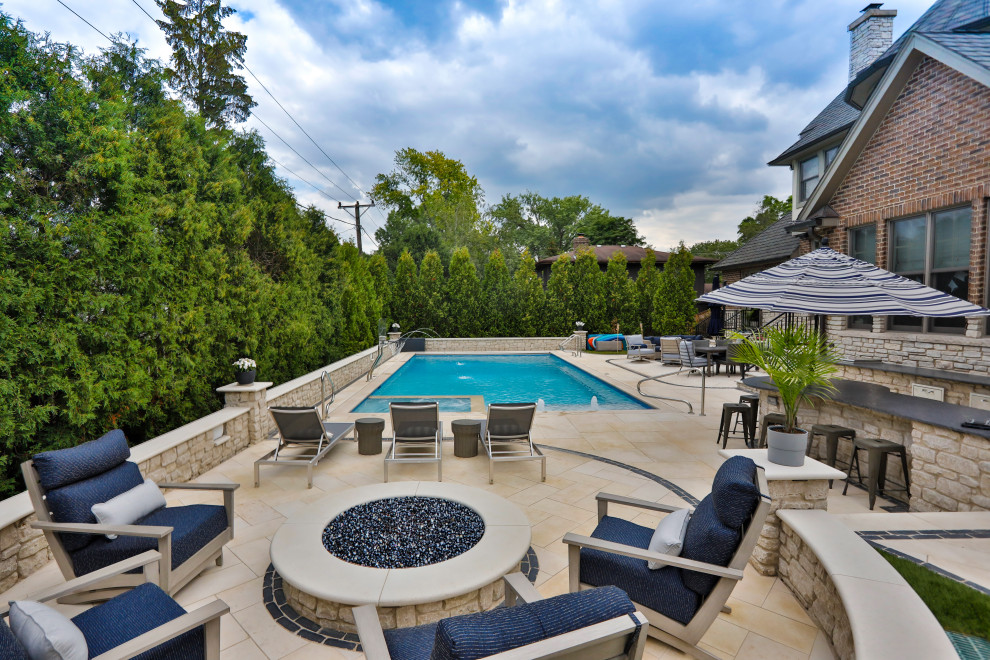 Immagine di una piscina monocorsia chic rettangolare di medie dimensioni e dietro casa con pavimentazioni in pietra naturale