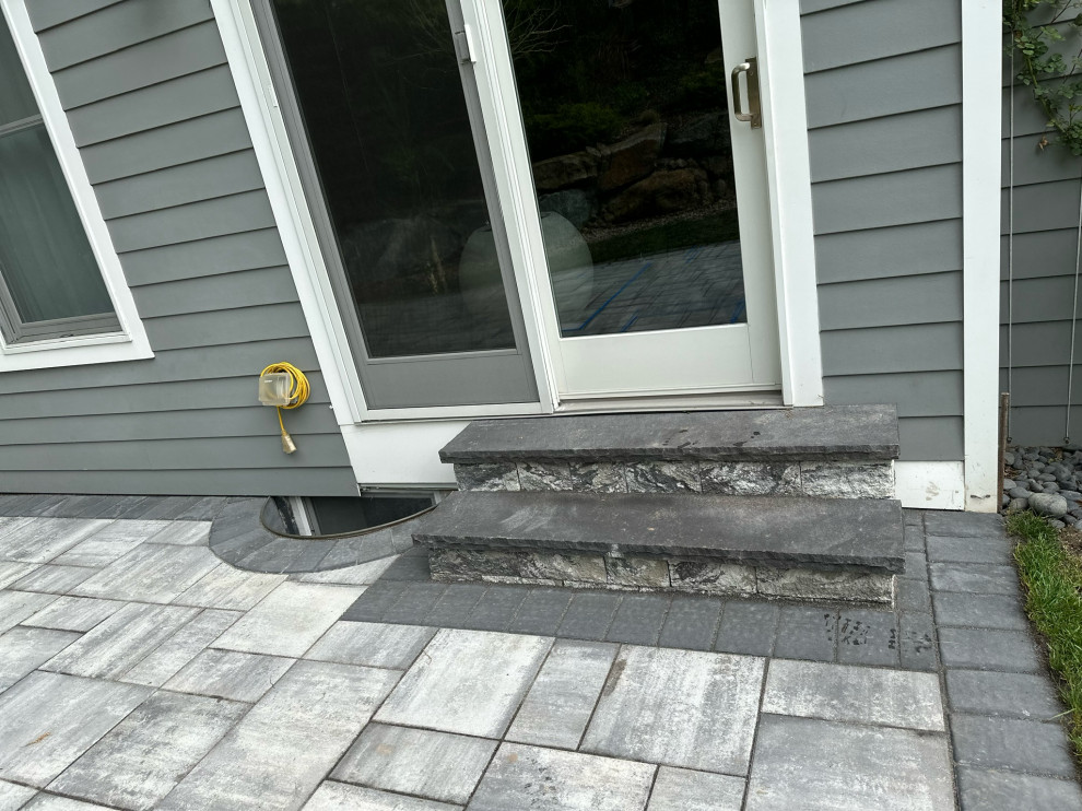 Esempio di un patio o portico minimalista dietro casa con pavimentazioni in mattoni