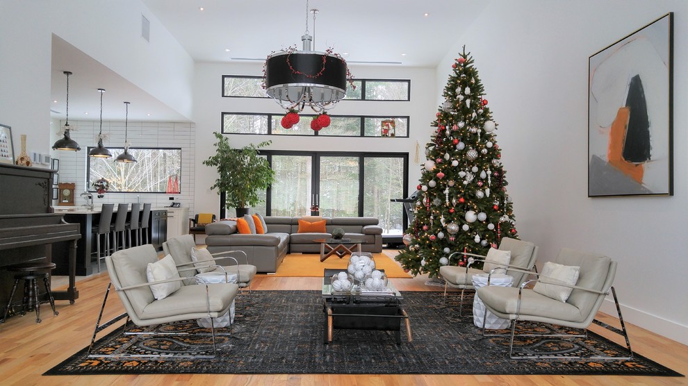 Large contemporary open concept living room in Montreal with white walls and light hardwood floors.