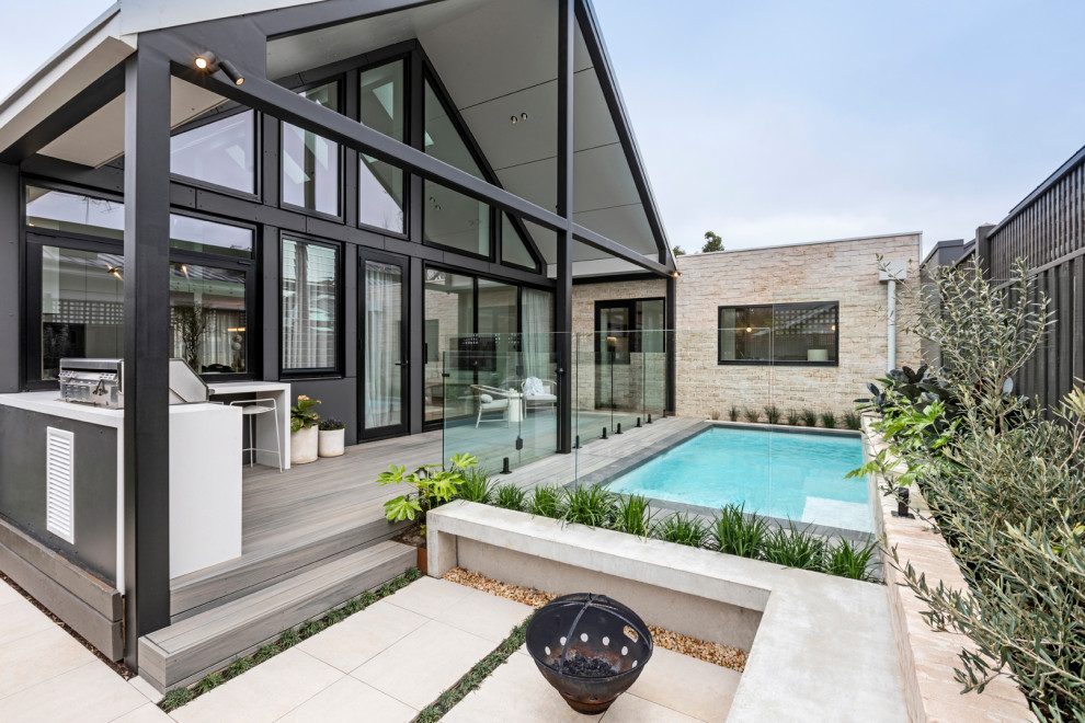 Moderner Garten hinter dem Haus mit Natursteinplatten in Melbourne