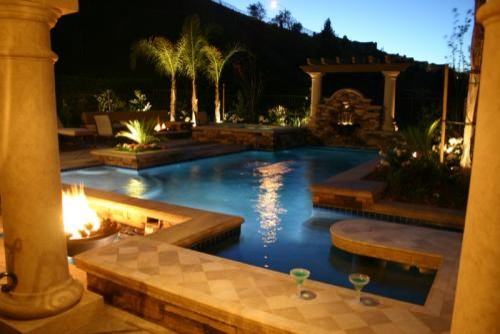 Photo of a small mediterranean backyard custom-shaped aboveground pool in Los Angeles with stamped concrete.
