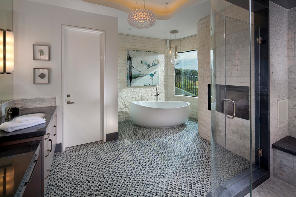 Design ideas for a mid-sized contemporary master bathroom in Orange County with flat-panel cabinets, medium wood cabinets, a freestanding tub, an alcove shower, white walls, mosaic tile floors, stone tile, an undermount sink and gray tile.
