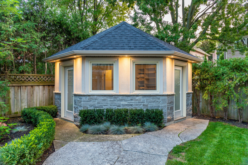 Mid-sized transitional backyard stamped concrete and rectangular pool house photo in Toronto