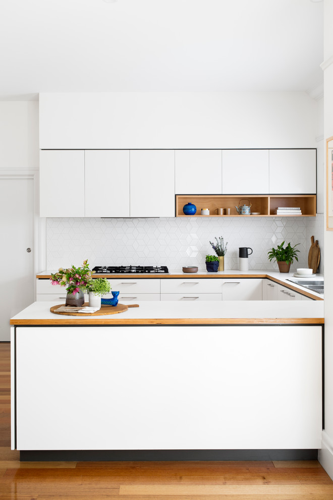 This is an example of a mid-sized contemporary kitchen in Melbourne with flat-panel cabinets and white cabinets.