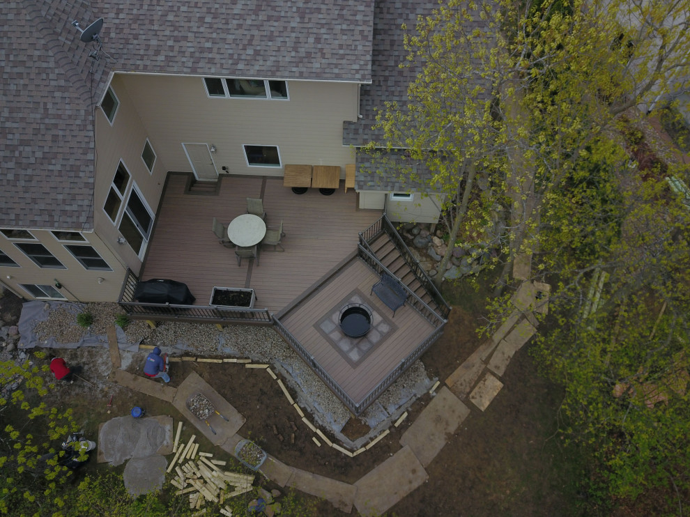 Example of a large backyard ground level metal railing deck design with no cover