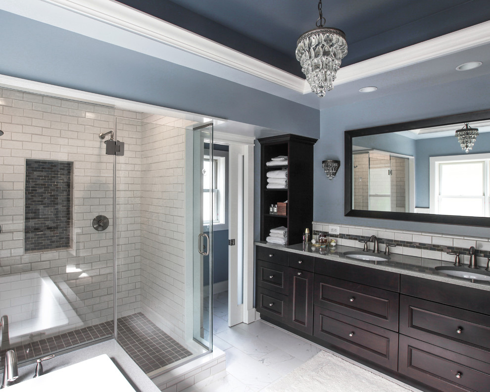 Inspiration for a large rustic master white tile and subway tile ceramic tile corner shower remodel in DC Metro with an undermount sink, recessed-panel cabinets, dark wood cabinets, solid surface countertops, an undermount tub, a two-piece toilet and blue walls