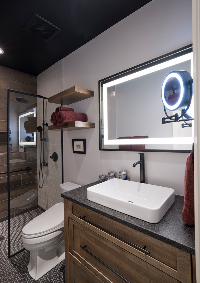 Example of a mid-sized trendy master brown tile and porcelain tile mosaic tile floor, black floor and single-sink bathroom design in DC Metro with shaker cabinets, medium tone wood cabinets, a bidet, gray walls, a vessel sink, granite countertops, black countertops, a niche and a freestanding vanity