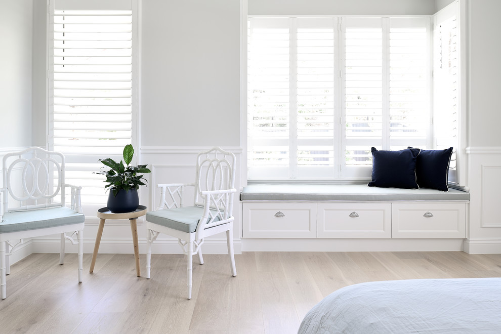 Imagen de dormitorio principal clásico de tamaño medio con paredes blancas, suelo de madera en tonos medios y suelo marrón