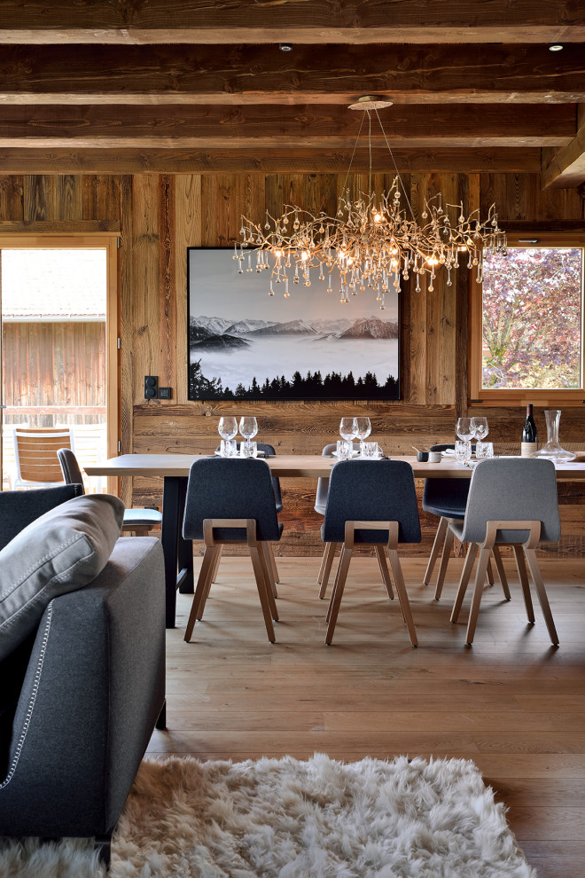 Imagen de comedor contemporáneo grande con suelo de madera clara, madera y vigas vistas