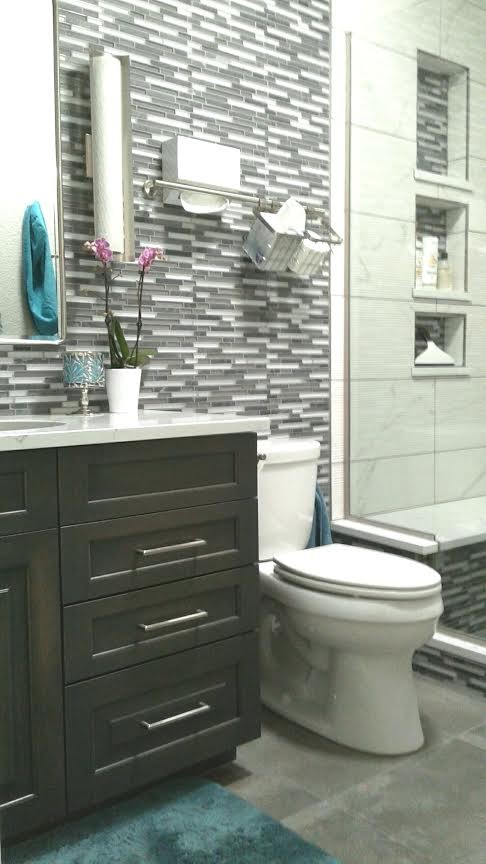 Example of a mid-sized transitional 3/4 gray tile, white tile and matchstick tile cement tile floor and gray floor alcove shower design with shaker cabinets, gray cabinets, a two-piece toilet, multicolored walls, an undermount sink, marble countertops and a hinged shower door