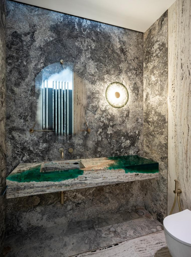 Пример оригинального дизайна: туалет среднего размера в стиле модернизм с унитазом-моноблоком, черно-белой плиткой, плиткой из травертина, белыми стенами, мраморным полом, монолитной раковиной, столешницей из травертина, белым полом, зеленой столешницей и подвесной тумбой