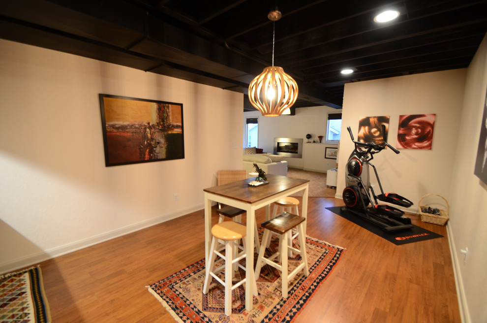 Inspiration for a mid-sized transitional walk-out vinyl floor basement remodel in Chicago with beige walls and a ribbon fireplace