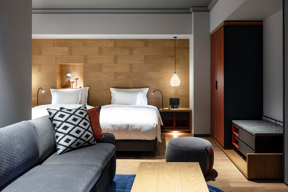 Expansive scandinavian guest bedroom in Osaka with brown walls, light hardwood floors, no fireplace, brown floor, wallpaper and wood walls.