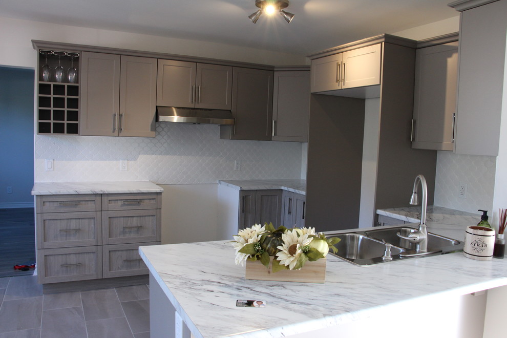 Mid-sized mountain style u-shaped porcelain tile eat-in kitchen photo in Toronto with a double-bowl sink, shaker cabinets, gray cabinets, laminate countertops, white backsplash, porcelain backsplash and a peninsula