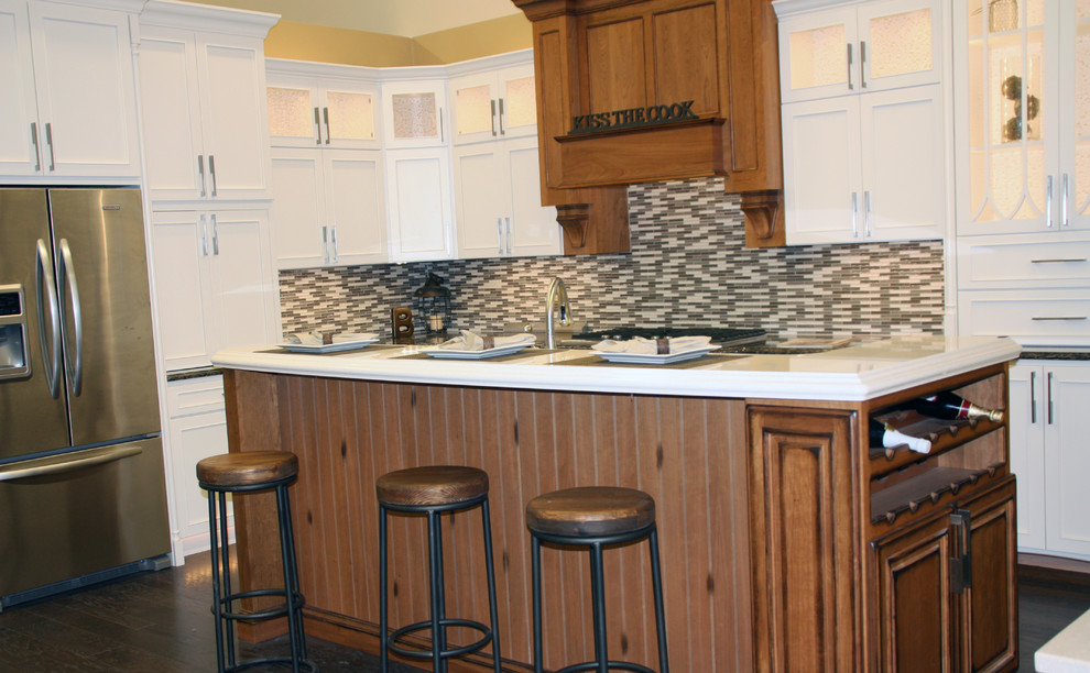 Large transitional l-shaped dark wood floor eat-in kitchen photo with shaker cabinets, white cabinets, multicolored backsplash, mosaic tile backsplash, stainless steel appliances, an island and quartz countertops