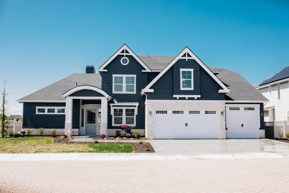 Photo of a beach style two-storey blue house exterior in Boise with concrete fiberboard siding, a gable roof, a shingle roof, a black roof and shingle siding.