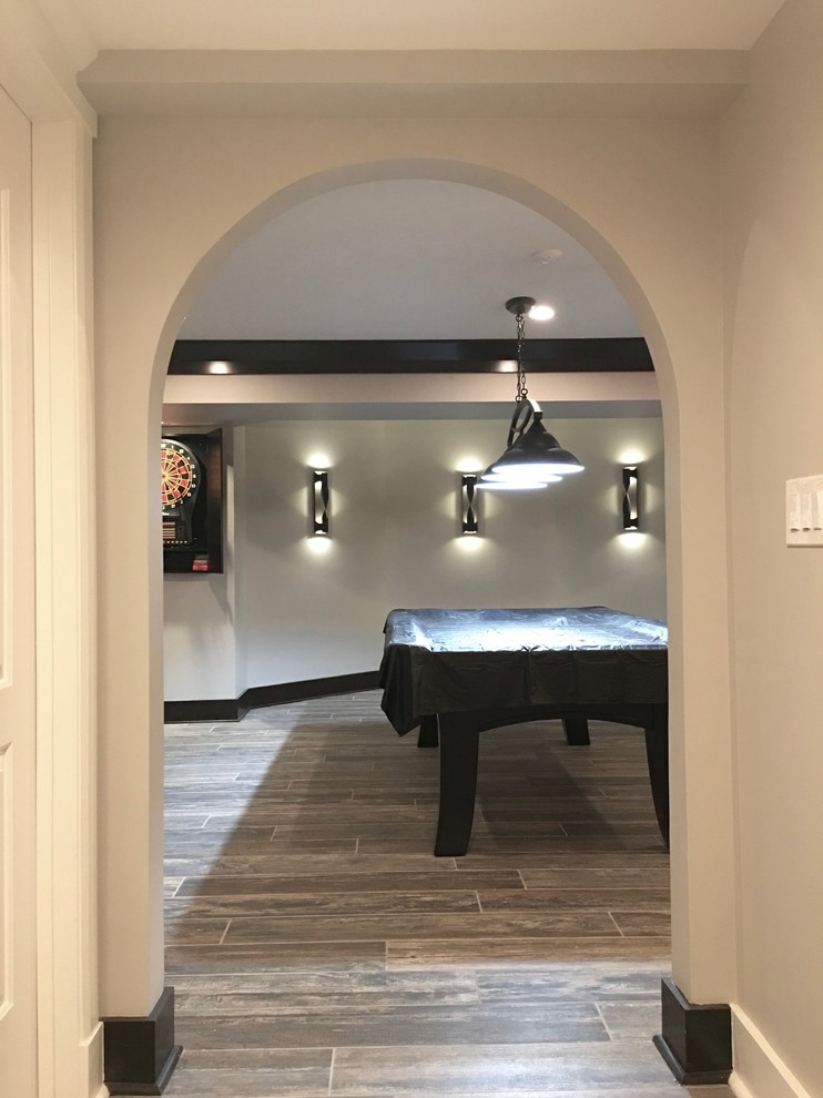 Example of a mid-sized transitional underground dark wood floor and brown floor basement design in Chicago with beige walls and no fireplace