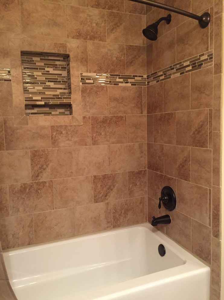 Design ideas for a mid-sized traditional bathroom in Other with raised-panel cabinets, brown cabinets, an alcove tub, a shower/bathtub combo, a two-piece toilet, brown tile, porcelain tile, beige walls, porcelain floors, an integrated sink and onyx benchtops.