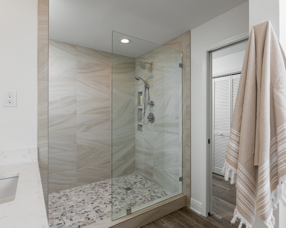 Photo of a large beach style master bathroom in Other with flat-panel cabinets, white cabinets, an open shower, a two-piece toilet, multi-coloured tile, porcelain tile, white walls, porcelain floors, an undermount sink, engineered quartz benchtops, brown floor and an open shower.
