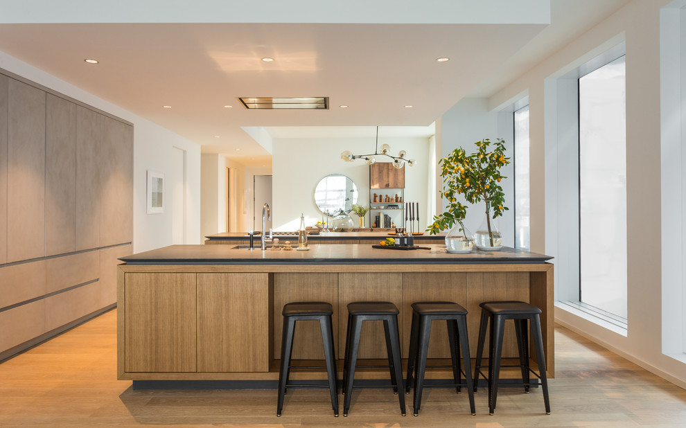 Example of a mid-sized trendy light wood floor and beige floor kitchen design in New York with white walls, no fireplace, an undermount sink, flat-panel cabinets, light wood cabinets and two islands