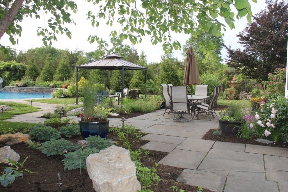 Design ideas for a large contemporary backyard patio in Philadelphia with natural stone pavers and a gazebo/cabana.