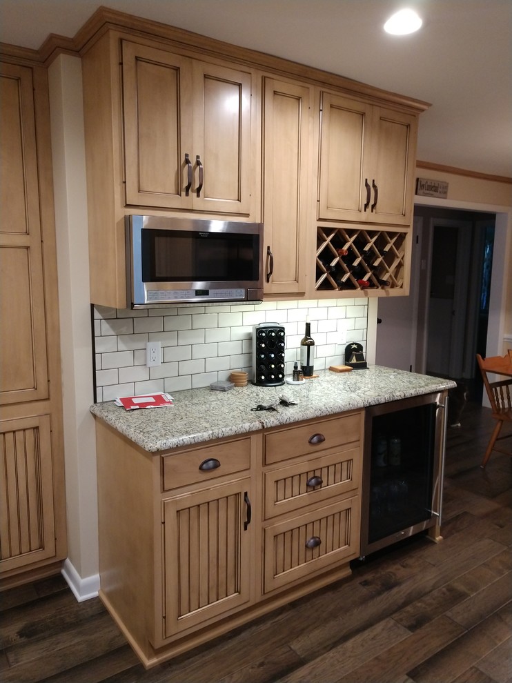 Home design - mid-sized rustic laminate floor and multicolored floor home design idea with distressed cabinets, granite countertops, white backsplash, subway tile backsplash, stainless steel appliances, no island and multicolored countertops