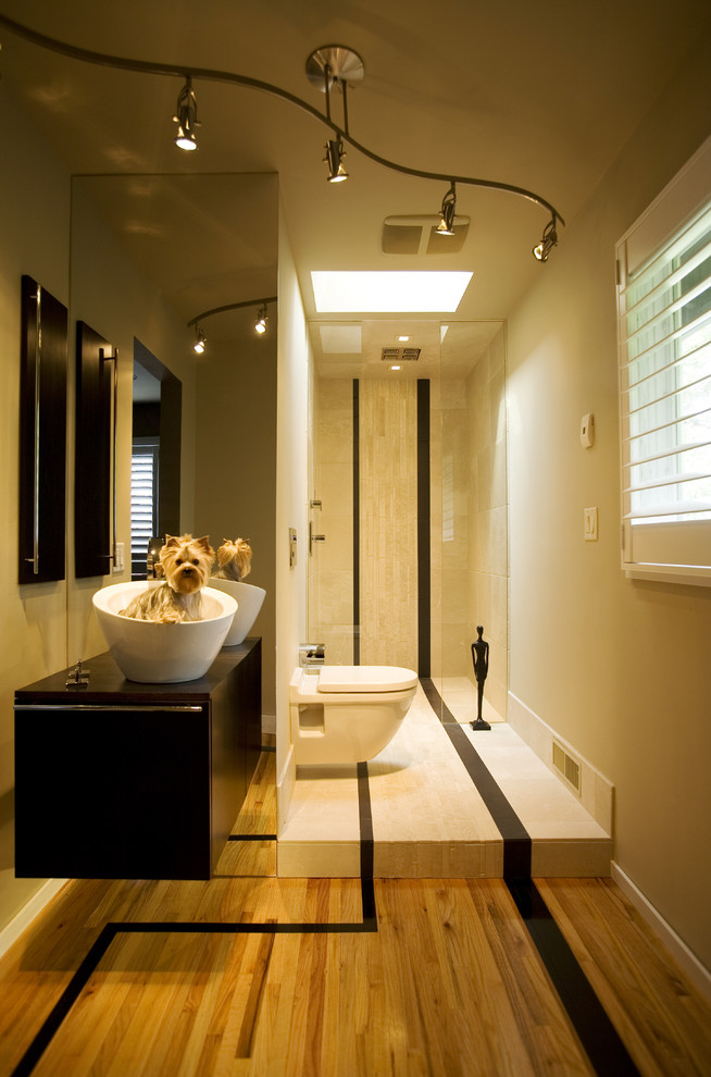 Photo of a small contemporary 3/4 bathroom in Minneapolis with a vessel sink, flat-panel cabinets, dark wood cabinets, wood benchtops, a curbless shower, a wall-mount toilet, beige tile, stone tile, beige walls and marble floors.