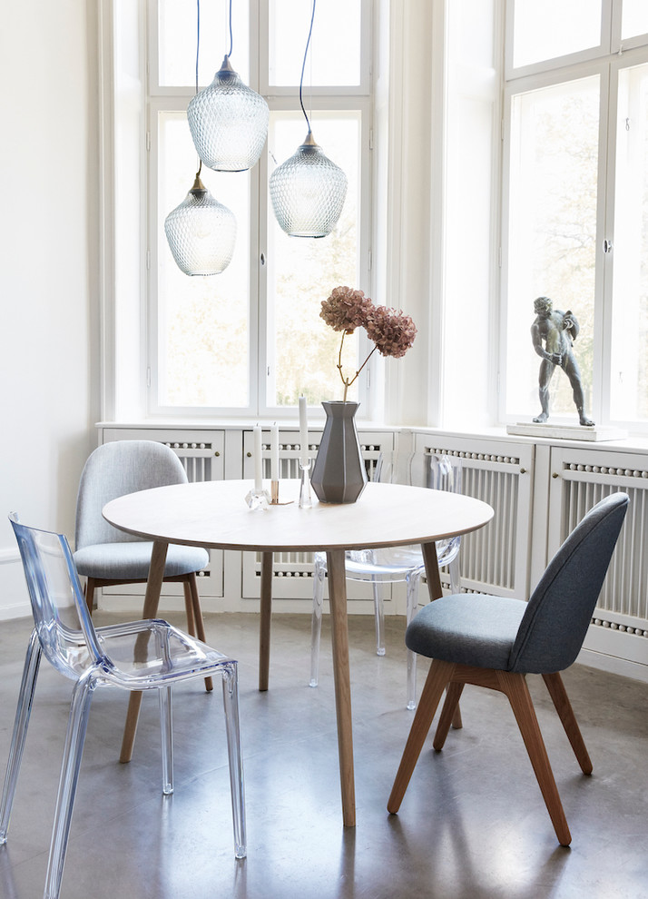 Mid-sized scandinavian dining room in Dresden with white walls and concrete floors.