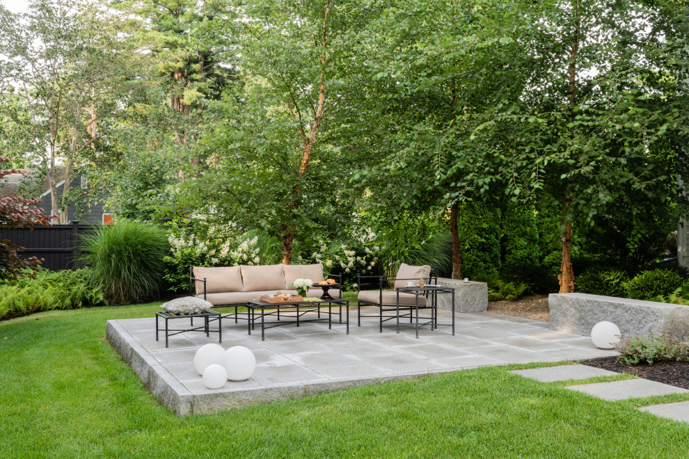 Transitional backyard patio in Boston with natural stone pavers.