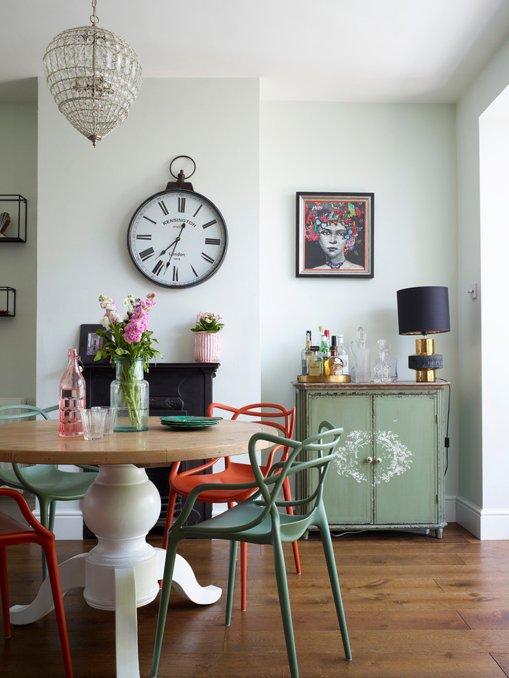 Design ideas for an eclectic dining room in London with white walls, medium hardwood floors and brown floor.