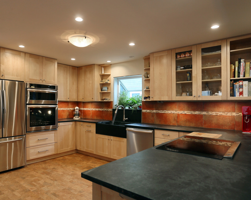 Photo of a large transitional u-shaped eat-in kitchen in Boston with a farmhouse sink, shaker cabinets, light wood cabinets, soapstone benchtops, multi-coloured splashback, stone tile splashback, stainless steel appliances, cork floors and a peninsula.