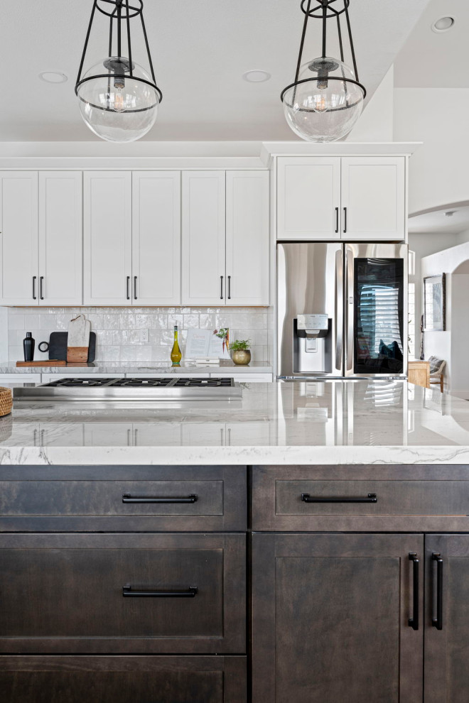 Inspiration for a transitional vinyl floor and brown floor kitchen remodel with a farmhouse sink, shaker cabinets, white cabinets, quartzite countertops, white backsplash and stainless steel appliances