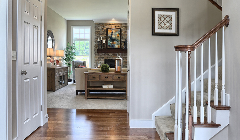This is an example of a mid-sized arts and crafts foyer in Other with medium hardwood floors, a dark wood front door and beige walls.