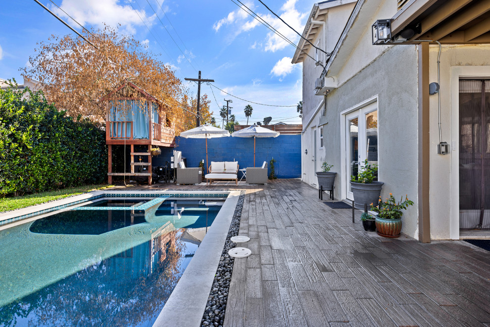 Foto de piscinas y jacuzzis alargados modernos de tamaño medio rectangulares en patio trasero con adoquines de hormigón