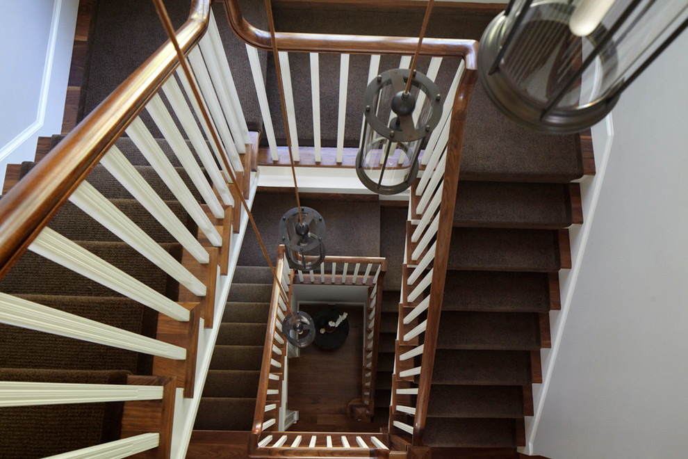 Expansive transitional wood spiral staircase in New York with wood risers.