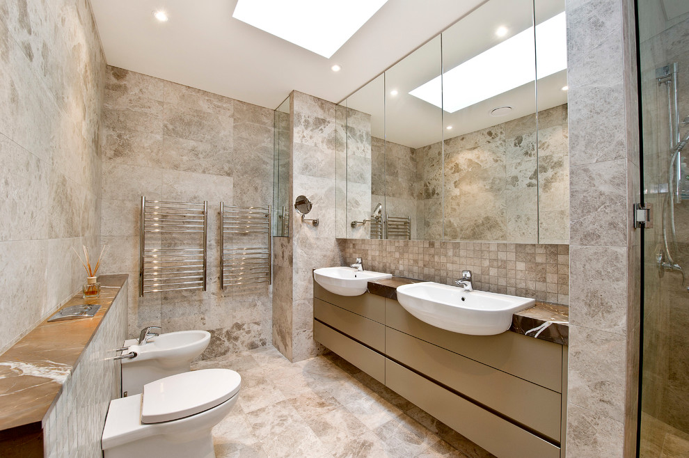 This is an example of a contemporary master bathroom in Sydney with a drop-in sink, flat-panel cabinets, beige cabinets, a one-piece toilet, beige tile and brown benchtops.